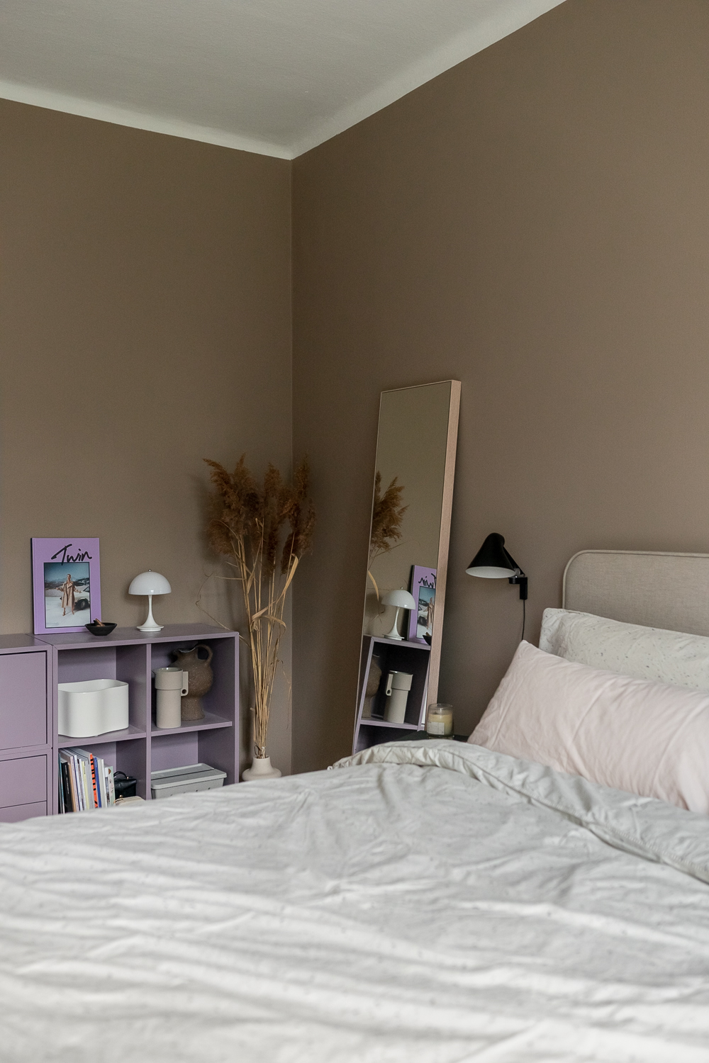 Beige Wandfarbe und Lila Sideboard im Schlafzimmer